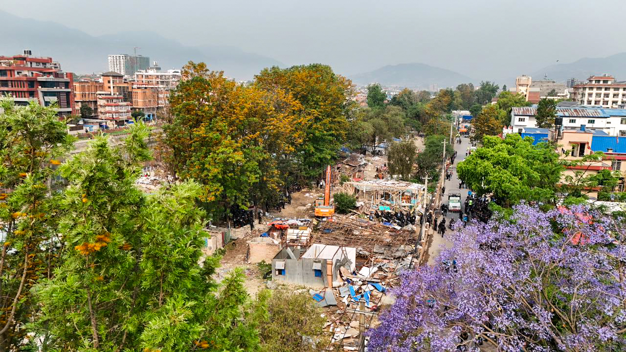 तस्वीरमा डोजर चलिरहेको थापाथलीको सुकुम्बासी बस्ती